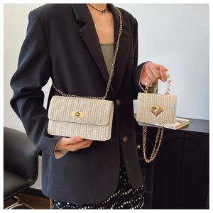 Detail of straw woven flap bag with gold lock and mini heart bag with pearl handle
