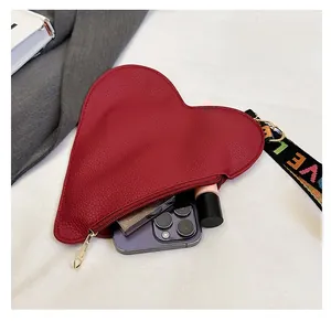 Red heart-shaped pouch with LOVE wristlet showing interior space for phone and makeup