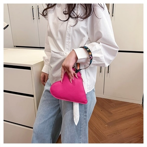 Detail of rose pink heart-shaped clutch with LOVE letter ribbon and zipper closure