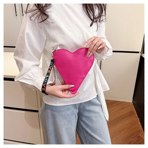 Détail de la pochette rose en similicuir en forme de cœur avec dragonne imprimée LOVE