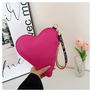 Détail du sac en forme de cœur rose fuchsia avec cuir grainé et sangle LOVE