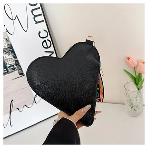 Détail du sac coeur en cuir noir avec large bandoulière imprimée LOVE colorée