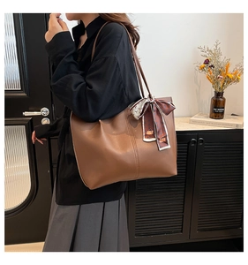 Brown leather tote bag with decorative silk scarf and large capacity for daily commuting
