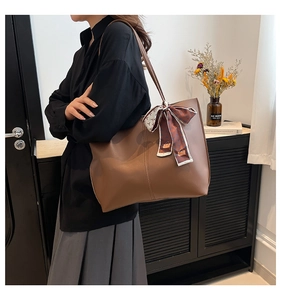 Brown leather tote bag with silk scarf detail and premium pebbled texture finish