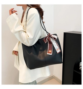 Classic black leather tote bag with printed silk scarf detail shown on model's shoulder