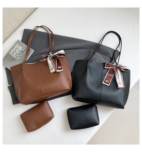 Detail of brown and black tote bag set with interior pouch and floral silk scarf accessory