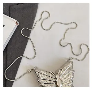 Detailed macro of silver butterfly crossbody bag with sparkling rhinestones and chain