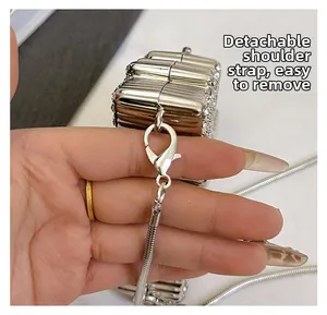 Detail of detachable metal snake chain strap with lobster clasp on silver clutch