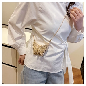 Detailed view of a gold butterfly-shaped mini bag with sparkling rhinestones and chain