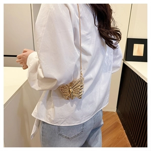 Detail view of butterfly shaped crossbody bag with gold rhinestones and chain strap