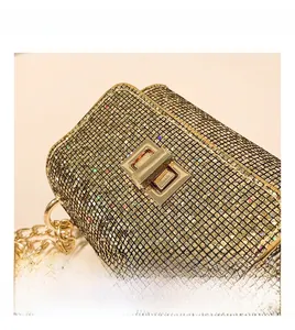 Macro view of sparkly sequined texture and golden metallic twist lock on a small square bag