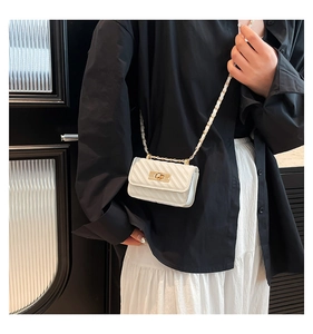White quilted micro chain bag with gold twist lock shown on model for scale and detail