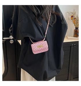 Detail of pink quilted mini crossbody bag with golden clasp and leather chain strap