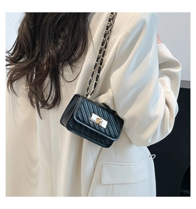 Detail of black quilted leather square bag with gold twist lock and chain strap