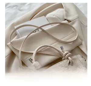 Detail showing beige lychee grain bucket bag with a stylish knotted top handle
