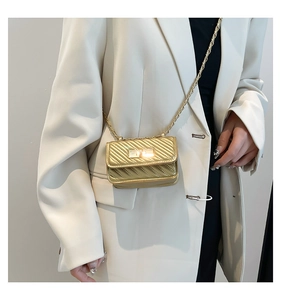 Mini quilted gold chain bag shown on white blazer for a stylish crossbody look