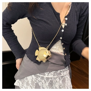 Detailed view of the fish-shaped gold metal mini bag with textured scales and chain strap
