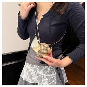 Detail view of goldfish-shaped gold metal evening bag with textured scales and chain