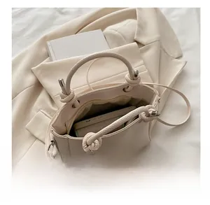 Top view of beige bucket bag showing interior storage capacity and knot handle detail