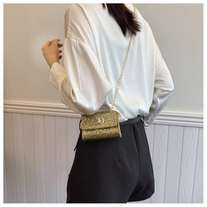 Detail of gold sequin mini crossbody bag with metal chain strap and twist lock