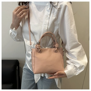 Detail of pink lychee grain leather bucket bag featuring FASHION & BAGS LEATHER logo