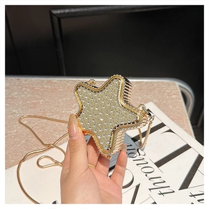 Detail of star-shaped evening bag with sparkling rhinestones and gold snake chain