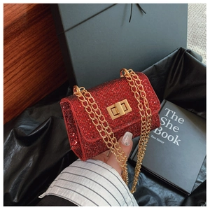 Close-up of elegant red rhinestone crossbody bag with gold chain and twist lock