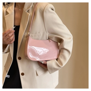 Detail of pink patent leather baguette shoulder bag with glossy finish and metal zipper