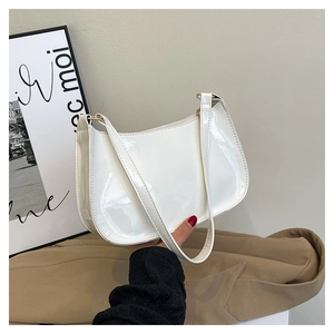 Close-up of elegant glossy patent leather on white retro baguette shoulder bag