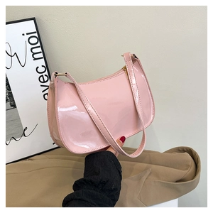 Detail of pink patent leather baguette bag with gold hardware and top zipper closure