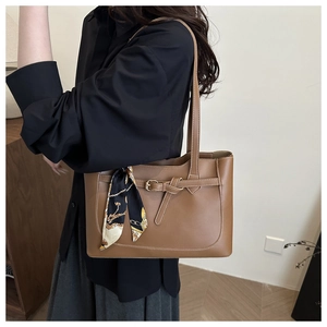 Detail of a brown PU leather tote bag featuring a decorative scarf and buckle detail