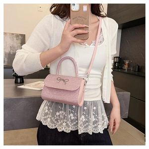 Selfie miroir d'un sac à bandoulière rose pailleté avec détail de nœud en métal
