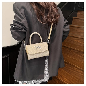 Détail du mini sac à paillettes roses avec nœud argenté et fine bandoulière