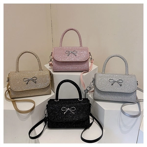 Glitter bow crossbody bags shown in gold pink silver and black on display stands