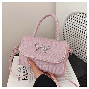 Detail of pink glitter texture and silver metal bow buckle on this small crossbody bag
