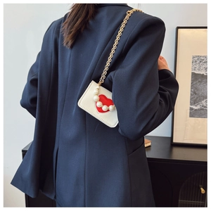 White heart-shaped mini crossbody bag with elegant pearl handle and gold chain detail