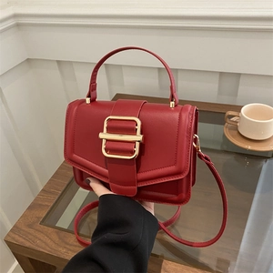 Elegant wine red structured handbag with gold buckle and adjustable strap