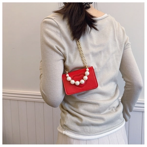 Détail du mini sac bandoulière coeur rouge avec poignée perle et chaîne dorée