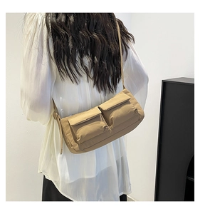 Vista posteriore di modella con borsa a tracolla in nylon kaki e due tasche frontali