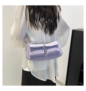 Lavender nylon crossbody bag with dual utility front pockets worn by model