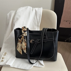 Chic black faux leather tote bag with contrast stitching and decorative scarf accessory