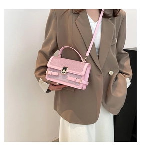 Close-up of pink glitter handbag with gold twist lock and adjustable shoulder strap