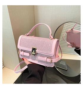 Detailed view of pink sequin crossbody bag with gold hardware and mirror reflection