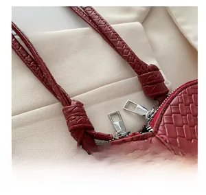 Detailed macro view of woven leather texture with dual silver zippers and knotted strap