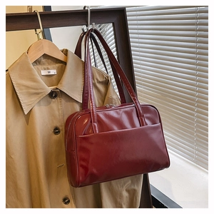 Detail of burgundy glossy leather tote bag with double zippers and long straps