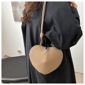 Close-up of heart-shaped beige crossbody bag with textured faux crocodile leather finish