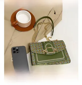 Détail du sac bandoulière en tweed vert avec fermoir doré ovale et bandoulière chaîne