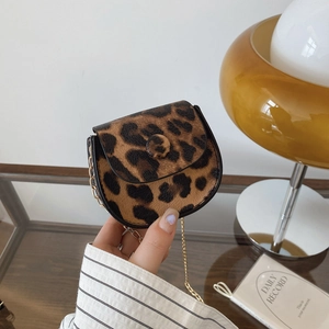 Mini sac à bandoulière léopard avec chaîne dorée présenté dans un décor rétro chic