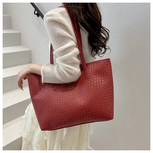 Detail showing the intricate woven leather texture and large capacity of this red tote bag