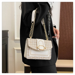 Détail du sac bandoulière en tweed et cuir avec chaîne dorée et fermoir ovale chic